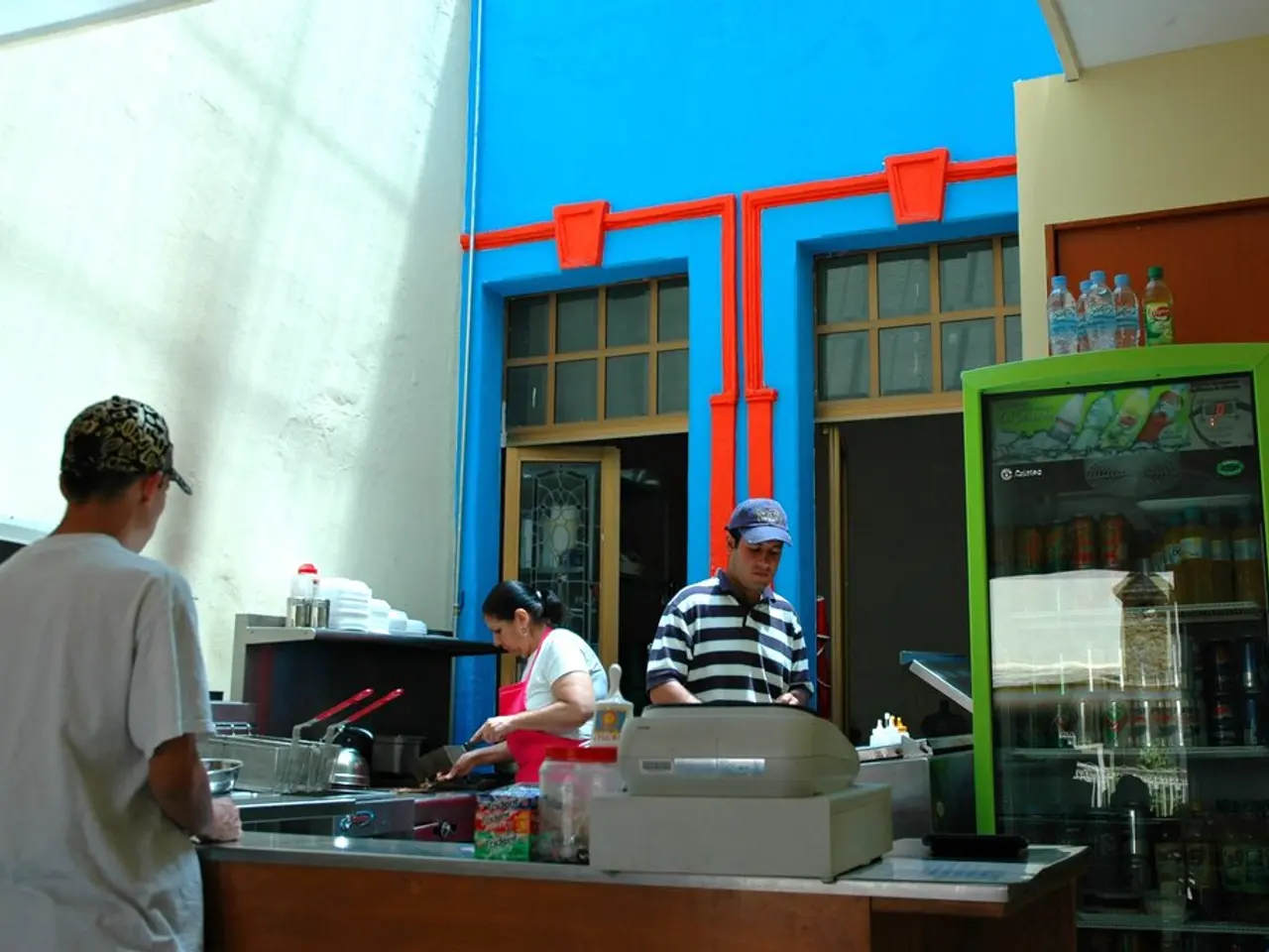 In this image there are three persons who are doing work at kitchen and at the right side of the...