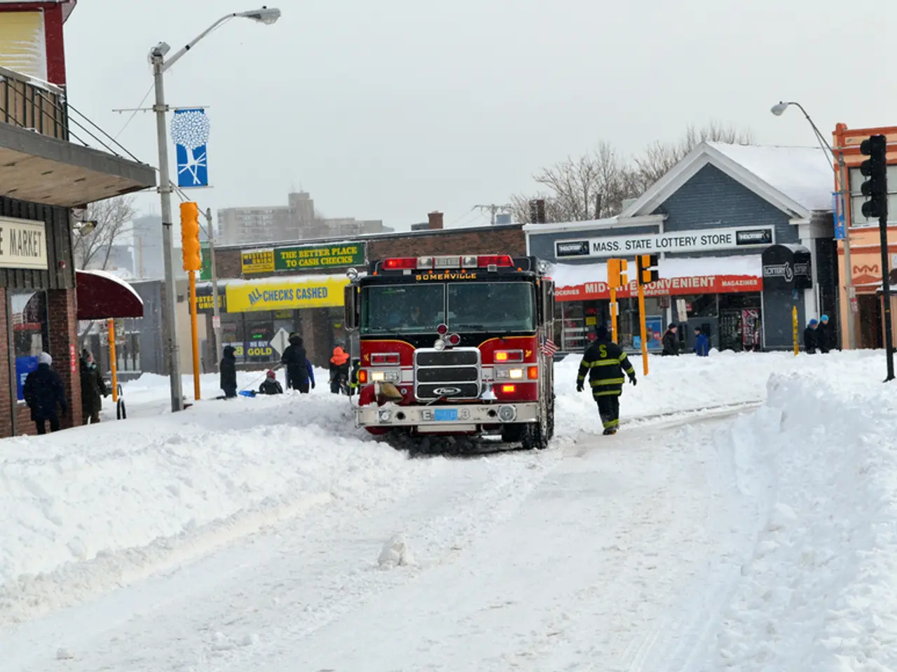 In this image it looks like a fire engine which is in the snow. There are buildings in the middle....