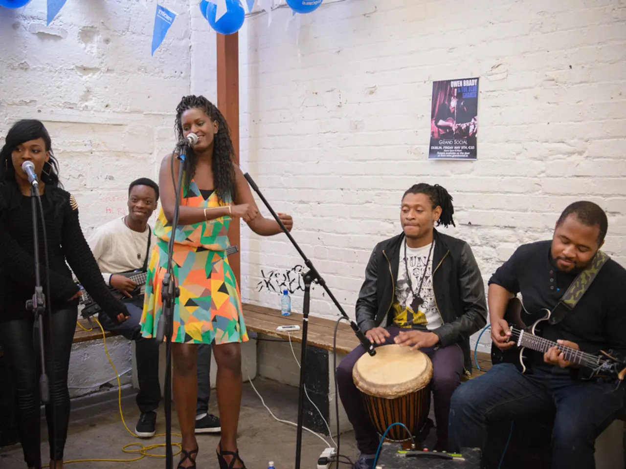 In this picture we can see five people among them there are sitting and playing some musical...
