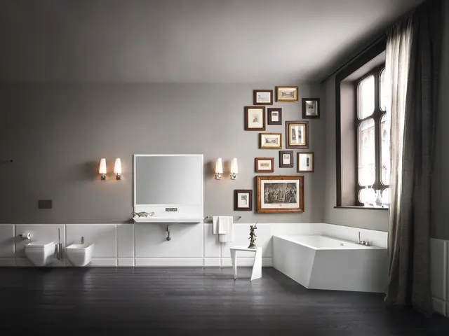 In this picture we can see frames on the wall, lamps, towels, stool on the floor with a statue on...