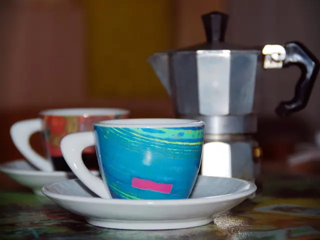 In the picture I can see two cups with saucers are kept on the table. It is looking like a flask on...