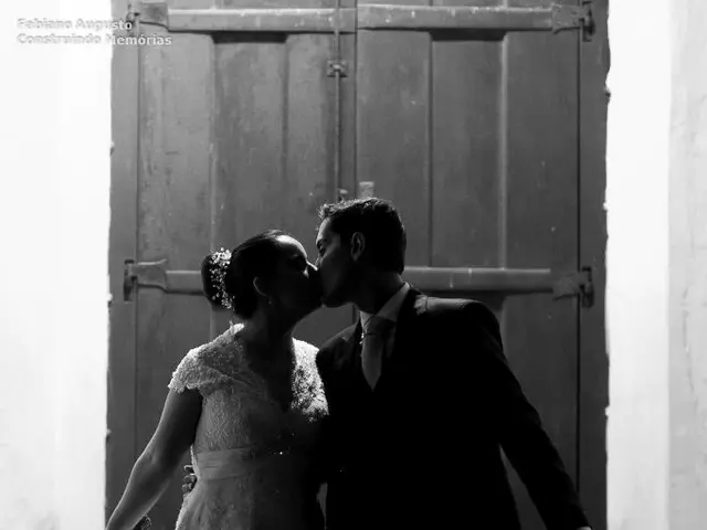 In this picture we can see a man and a woman are kissing, this man is holding an umbrella, this...