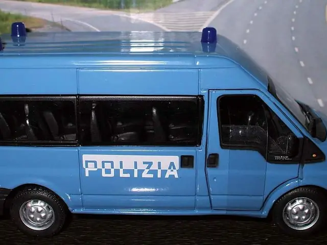 In the image there is a toy vehicle, behind that there is some poster.