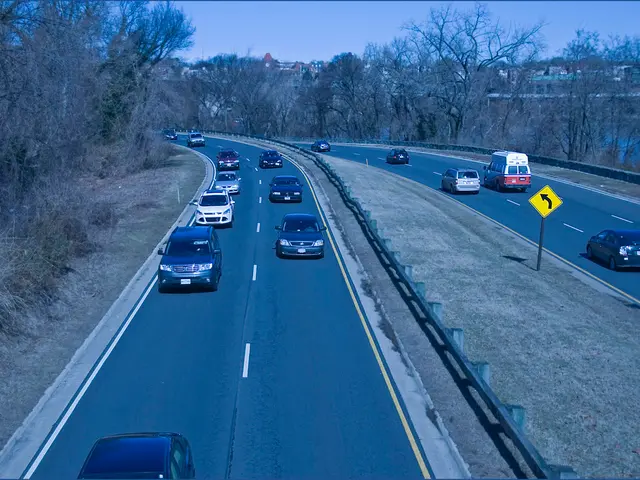 At the bottom of the image there is a road and we can see cars and vans on the road. There is a...